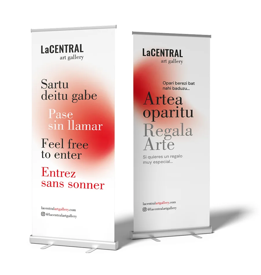 Roll-ups publicitarios de LaCentral Art Gallery con diseño minimalista, tipografía elegante y mensaje multilingüe sobre entrar libremente y regalar arte.